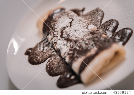 Delicious pancakes topped with chocolate and sugar powder 45939134