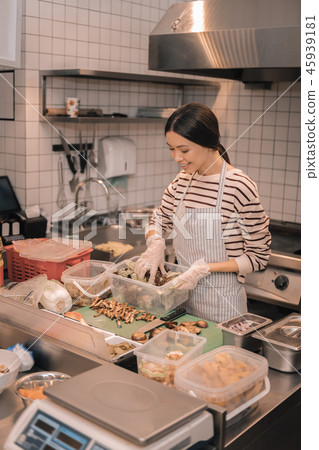 Top view of helpful waitress helping in the kitchen cutting food Top view of helpful waitress helping in the kitchen cutting food 45939181