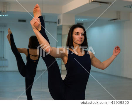Young woman doing yoga pose and asana. Beautiful woman enjoying yoga indoors in sport clothes 45939200