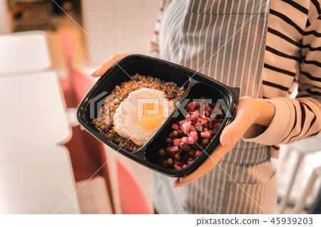 Waitress holding box with some buckwheat with egg and beetroot salad Waitress holding box with some buckwheat with egg and beetroot salad 45939203