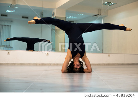 Young woman doing headstand yoga pose and asana. Beautiful woman enjoying yoga indoors in sport Young woman doing headstand yoga pose and asana. Beautiful woman enjoying yoga indoors in sport 45939204
