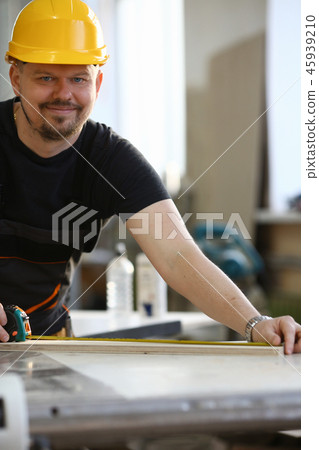 Arms of worker measuring wooden bar closeup Arms of worker measuring wooden bar closeup 45939210