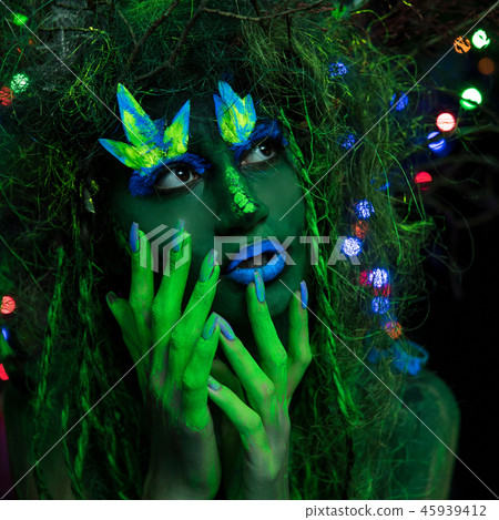Mystic green dryad in UV fluor black light with Glowing trees on background Mystic green dryad in UV fluor black light with Glowing trees on background 45939412