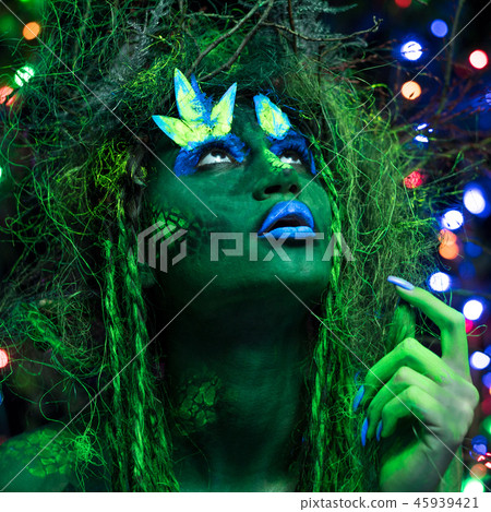 Mystic green dryad in UV fluor black light with Glowing trees on background Mystic green dryad in UV fluor black light with Glowing trees on background 45939421