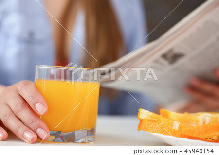 Beautiful woman hold in arms glass of orange juice Beautiful woman hold in arms glass of orange juice 45940154