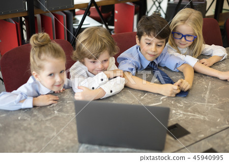 Little children businessmen work in the office and use a laptop. 45940995