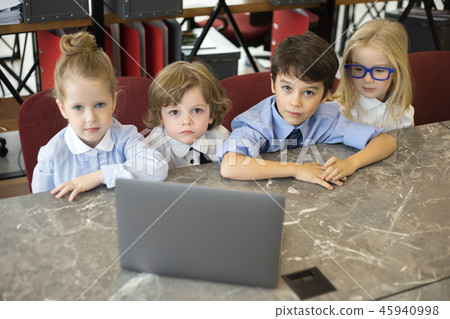 Little children businessmen work in the office and use a laptop. 45940998
