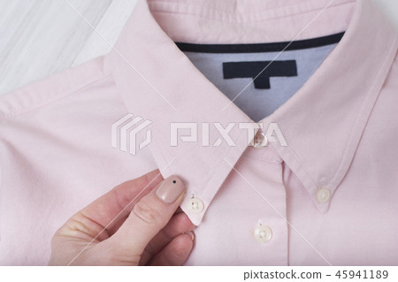 Collar of pink shirt in female hand 45941189