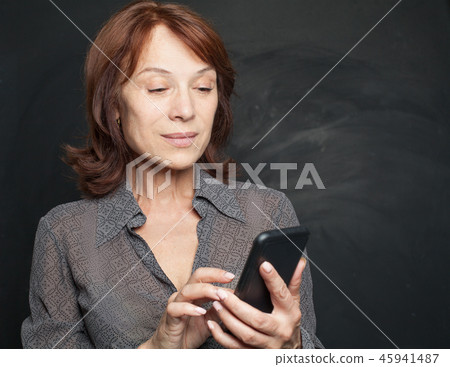 Mid adult business woman with smartphone Mid adult business woman with smartphone 45941487