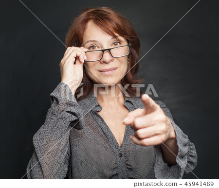 Mature business woman in glasses pointing Mature business woman in glasses pointing 45941489