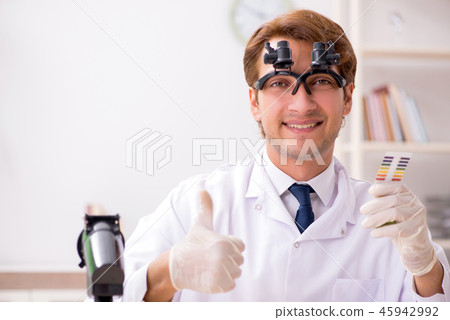 Chemist in the lab checking with ph strips 45942992