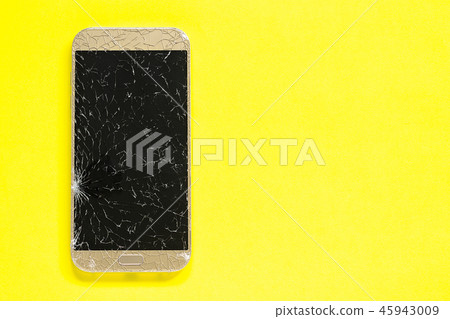Broken cracks cell mobile phone, yellow background 45943009