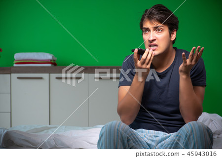 Young handsome man suffering from insomnia at home Young handsome man suffering from insomnia at home 45943016