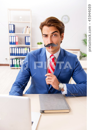 Funny bisinessman with fake moustache in the office 45944089