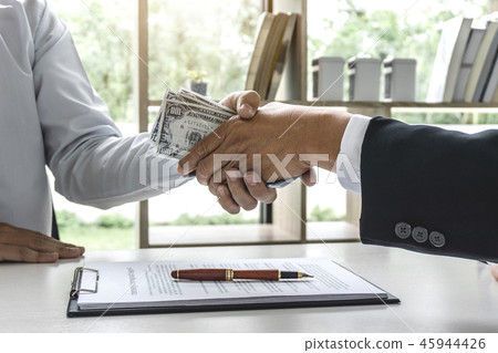 Businessman handshake money of dollar bills in hands from while Businessman handshake money of dollar bills in hands from while 45944426
