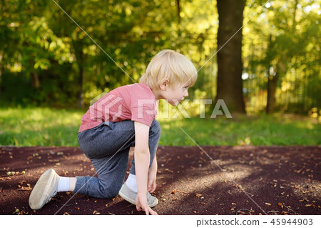 Little boy sportsman getting ready to run Little boy sportsman getting ready to run 45944903