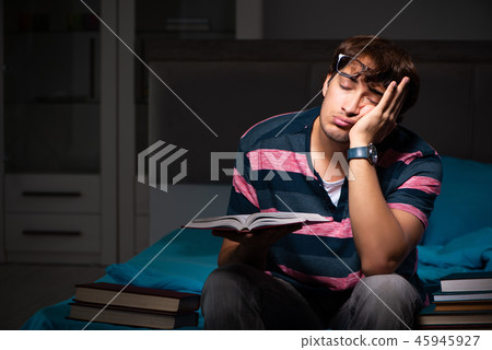 Young handsome student preparing for exams at night Young handsome student preparing for exams at night 45945927