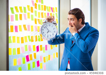 Young handsome employee with many conflicting priorities Young handsome employee with many conflicting priorities 45946308