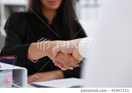 Man and woman shake hands as hello in office closeup 45947133