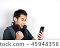 Excited man playing on smartphone 45948358