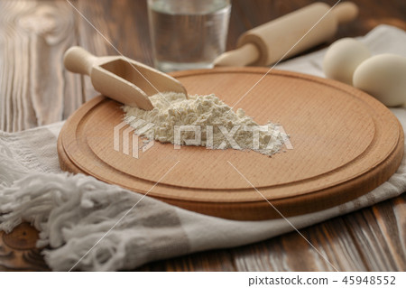 Flour in a wooden spoon on a cutting board 45948552