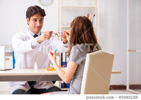 Young woman visiting male doctor ophthalmologist in hospital Young woman visiting male doctor ophthalmologist in hospital 45949189