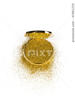 Powder highlighter in a gold powder box with gold sparkles reflected in the mirror. Isolated on Powder highlighter in a gold powder box with gold sparkles reflected in the mirror. Isolated on 45962259