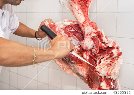 butcher cutting a large piece of meat 45965555