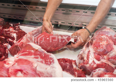 butcher showing a piece of meat to a customer butcher showing a piece of meat to a customer 45965560