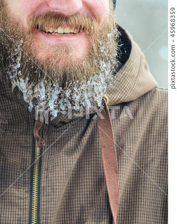 Smiling young man with beard in icicles Smiling young man with beard in icicles 45968359