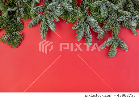 Christmas composition. Christmas red decorations, fir tree branches with bumps on red background 45968755