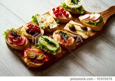 wooden board with colorful healthy mini sandwiches or tapas on a wooden table wooden board with colorful healthy mini sandwiches or tapas on a wooden table 45970076