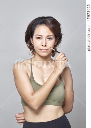Closeup beautiful woman with eyebrow brush tool on gray Closeup beautiful woman with eyebrow brush tool on gray 45973423