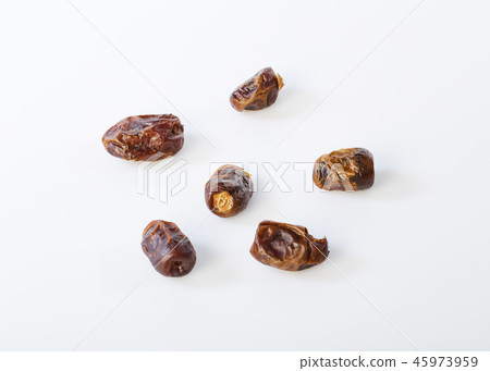 Dried halawi dates on a white 45973959