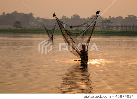 Catching fish on lake at sunrise Catching fish on lake at sunrise 45974034