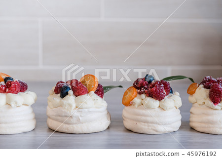 Pavlova meringue cake with cream and small fruits Pavlova meringue cake with cream and small fruits 45976192