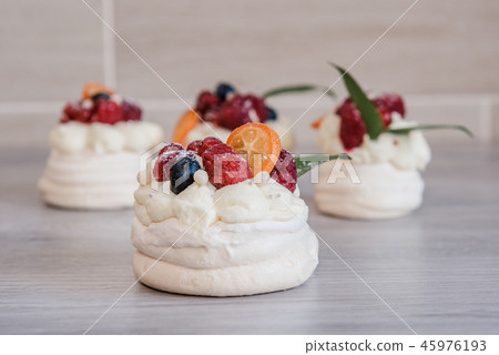 Pavlova meringue cake with cream and small fruits Pavlova meringue cake with cream and small fruits 45976193