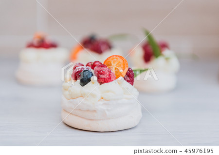 Pavlova meringue cake with cream and small fruits Pavlova meringue cake with cream and small fruits 45976195