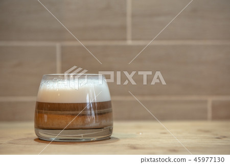 multilayer coffee or cappuccino in a glass cup on wooden table 45977130