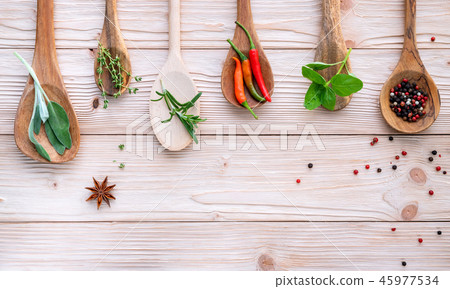 Various of spices and herbs in wooden spoons.  45977534