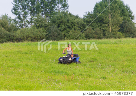 Elegant woman riding quadrocycle on spring field 45978377