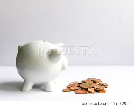 Piggy bank with coins. White ceramic moneybox. Piggy bank with coins. White ceramic moneybox. 45982903