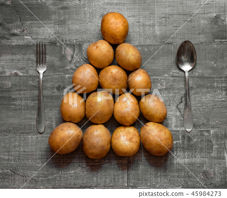 Some potatoes on an old wooden table or wooden sur Some potatoes on an old wooden table or wooden sur 45984273
