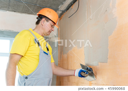 The construction worker putty a wall. 45990068