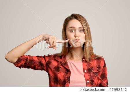 Close-up of childish student woman blowing cheeks  45992542