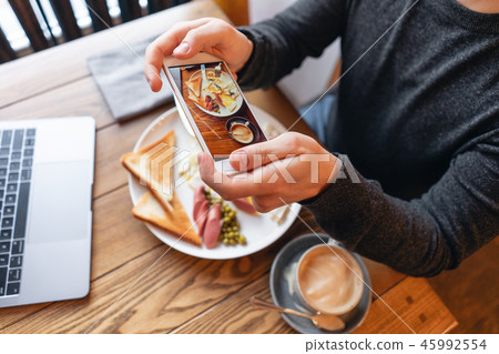 Blogger takes pictures of the Breakfast on the smartphone. Concept of creating content for social 45992554