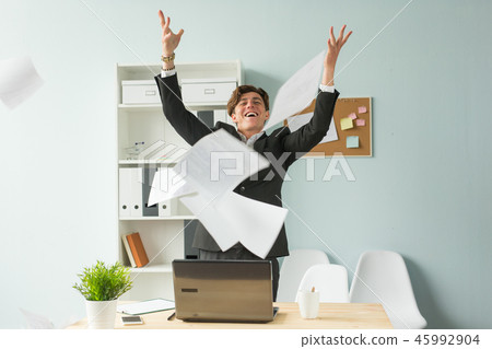 Business people, joke and fun concept - happy funny businessman throwing papers in office 45992904