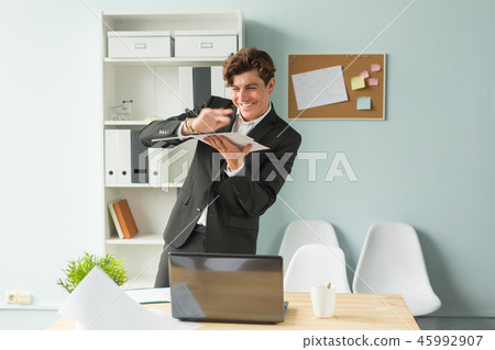 Business, joke, people concept - happy man throwing the paper because he has finished his work 45992907