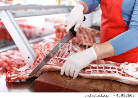 Close-up of butcher cutting quality porks Close-up of butcher cutting quality porks 45998608