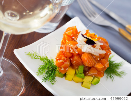 Cube of delicious salmon tartare garnish with avocado on plate at cafe Cube of delicious salmon tartare garnish with avocado on plate at cafe 45999022